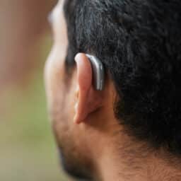 Close up photo of a man wearing a behind-the-ear hearing aid